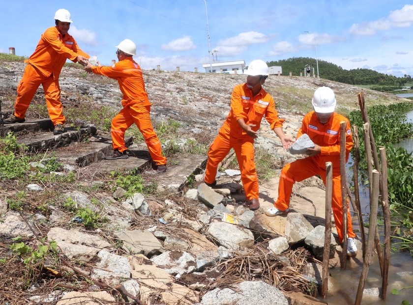 Nhân viên Công ty Thủy điện An Khê-Ka Nak xử lý tình huống sạt lở cục bộ mái đập thượng lưu bờ trái đập dâng An Khê. Ảnh: Ngọc Minh